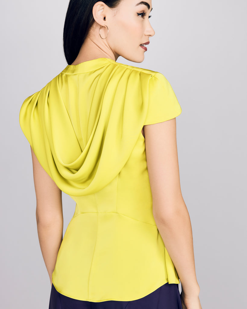 Blouse from D2Line showcases delicate cap sleeves and a draped cowl cape at the back 