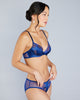 The Veronique Cobalt lingerie set is crafted from a combination of bright blue silk and ultra-soft mesh with metallic purple floral lace appliqué 
