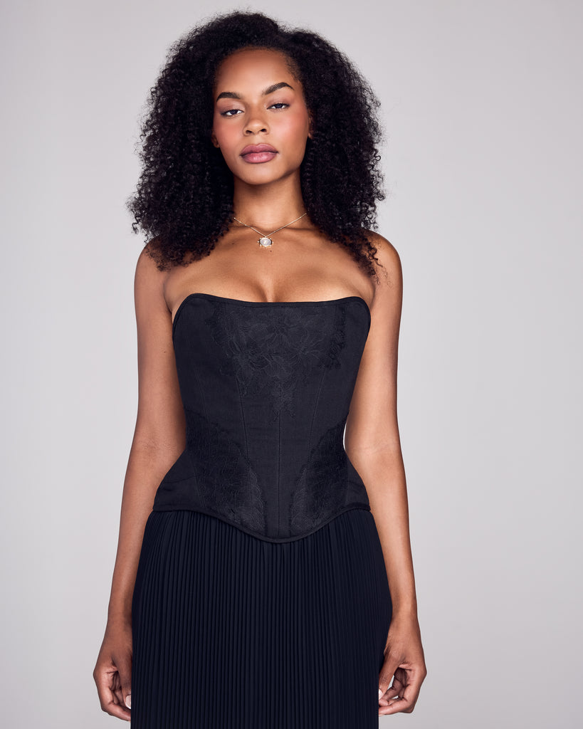 Classic corset from FrancesKa is crafted from black denim with beautiful black lace appliqué at the center neckline and arching over the hips