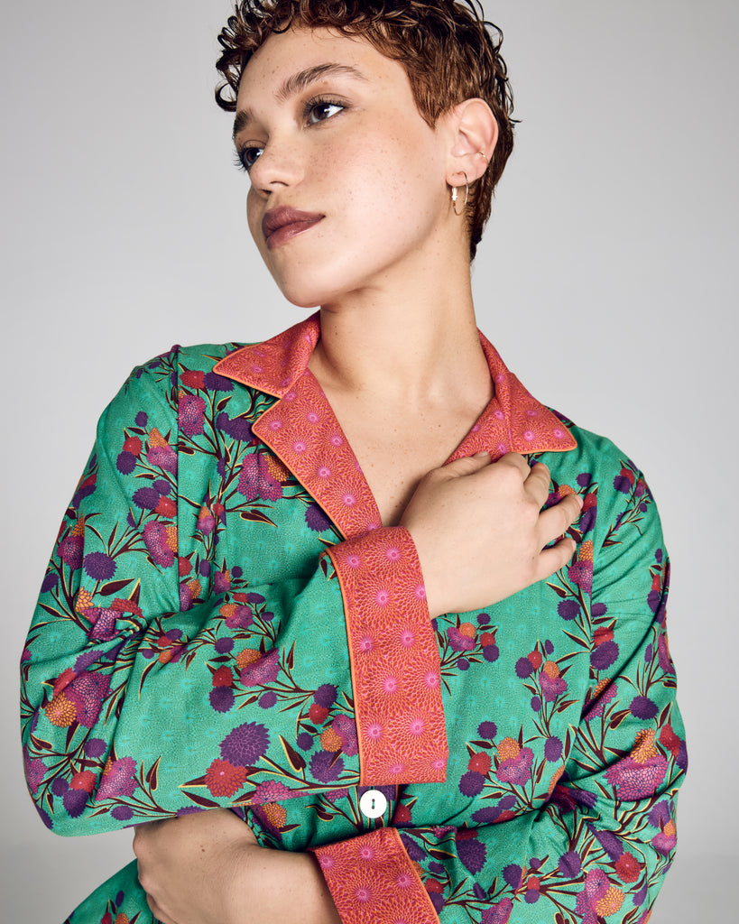 The classic button-down top on Karma's Isa Sayuri Jade pajama has a generous fit with a notched collar, orange piping, and contrast print at the collar, cuffs and hem