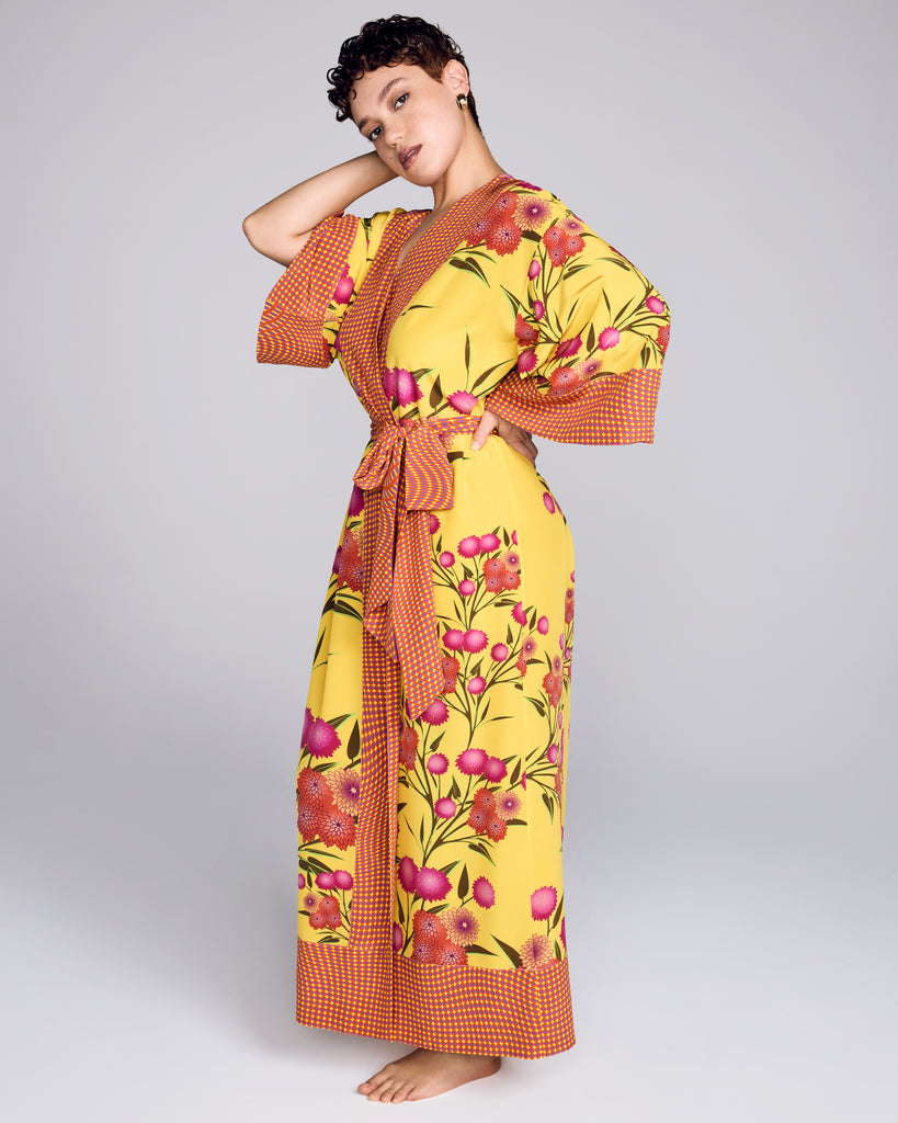 The Kobe Yuri Yellow full length robe from Karma on the Rocks is crafted from a bright yellow silk crepe with a pink and orange floral print, with a contrasting psychedelic geometric print in shades of yellow, orange and purple