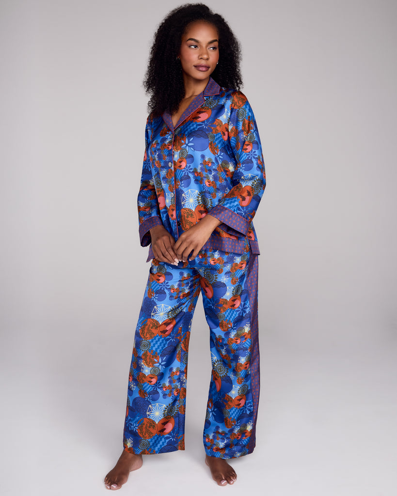 Exquisite Tama Blue silk pajama from Karma on the Rocks is crafted from a luxurious blue silk twill with a Japanese-inspired print showcasing clouds, suns, foliage and geometric designs in shades of blue, red, black and gold 