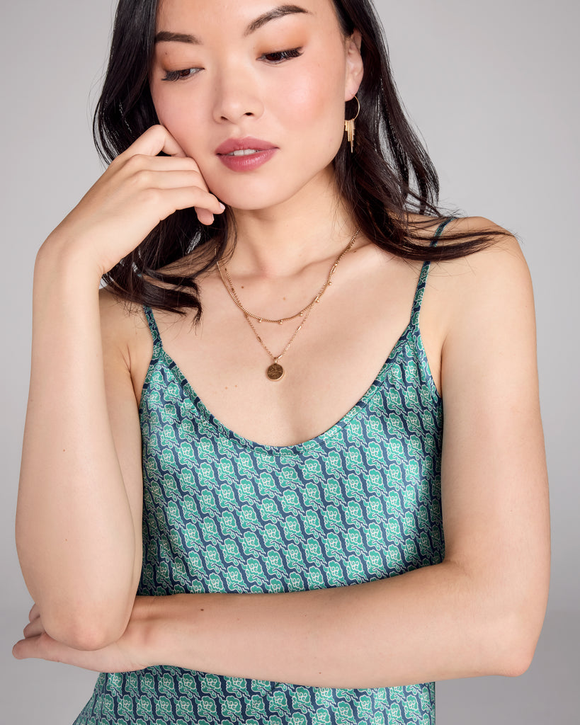 The Kumo Green Edo Silk slip dress from Karma on the Rocks is crafted from a navy blue silk charmeuse with a teal, green and white cloud pattern