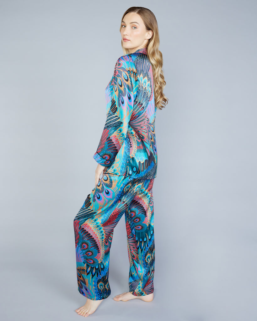 Christine Vancouver's Erte silk pajamas showcases an exquisite Art Deco print in shades of teal, blue, purple, red, gold, and fuchsia 