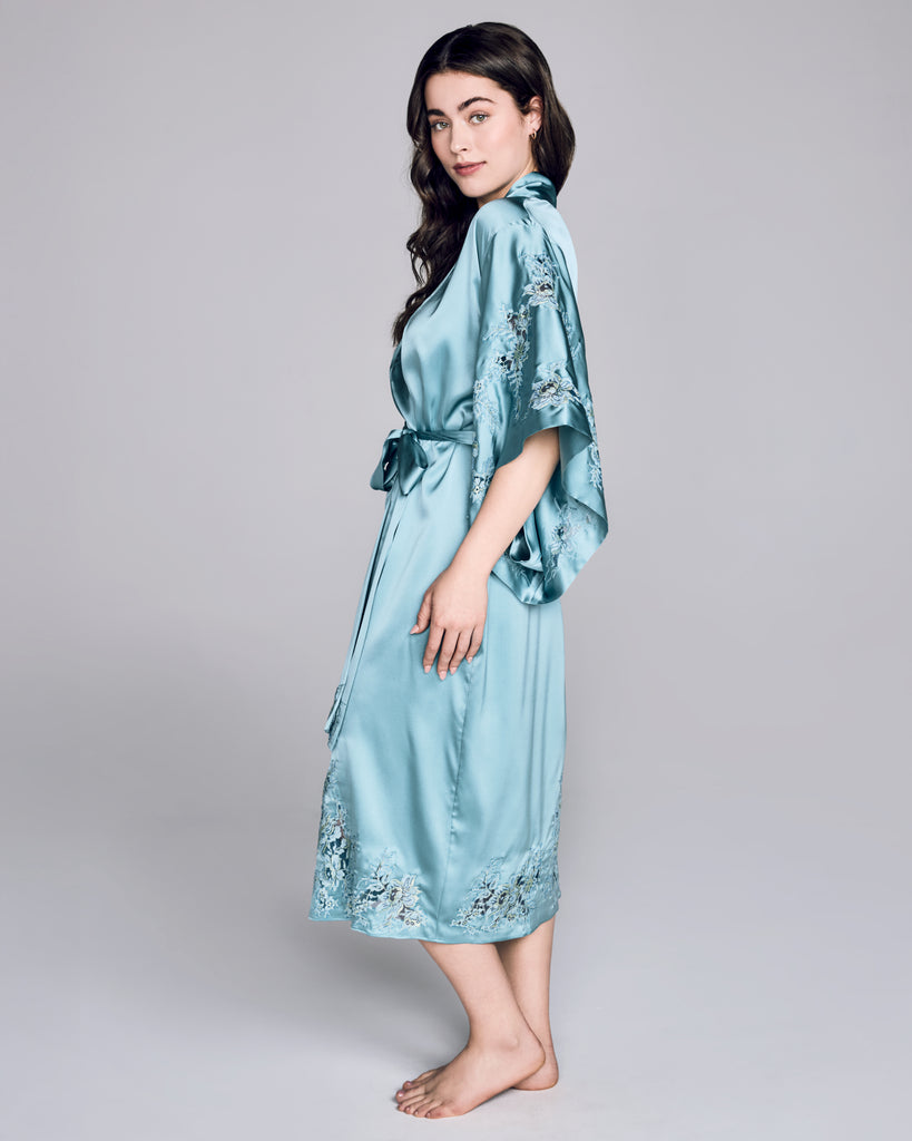 Sublime Astri silk robe from Emma Harris is crafted from a vibrant blue silk with tonal blue and green floral lace appliqué