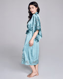 Sublime Astri silk robe from Emma Harris is crafted from a vibrant blue silk with tonal blue and green floral lace appliqué