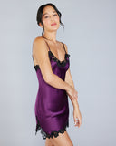 The Clara silk slip from Emma Harris is crafted from a rich purple silk with shimmering black floral lace appliqué at the entire top and hem