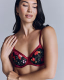 The Kalea lingerie set by Emma Harris is crafted from red silk and an exquisite black lace with green leaf embroidery and textural silk appliquéd to look like flowers in shades of red, toffee, purple and pink