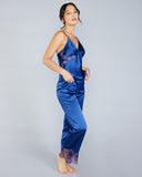 The Veronique silk camisole and lounge pant set from Emma Harris is crafted from a bright cobalt blue silk with shimmering metallic purple lace appliqué 