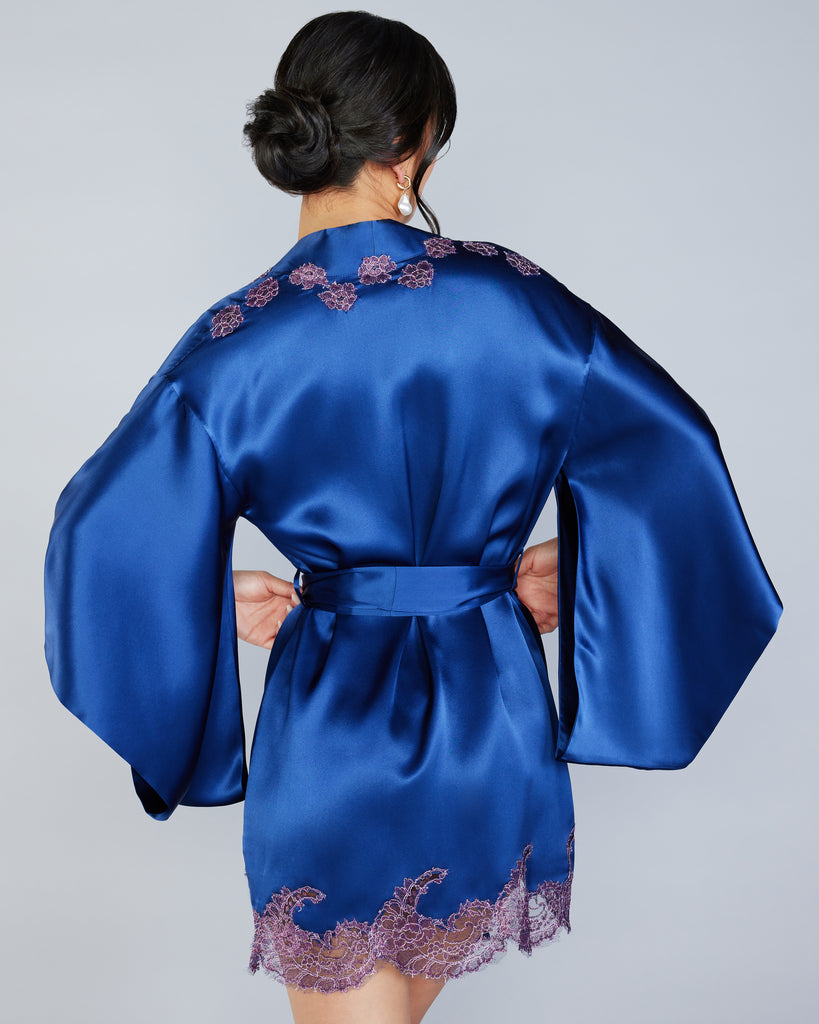 Bright blue Veronique silk kimono robe from Emma Harris has metallic purple lace appliqué around the full hem, at the shoulders, and at the ends of the long silk ties
