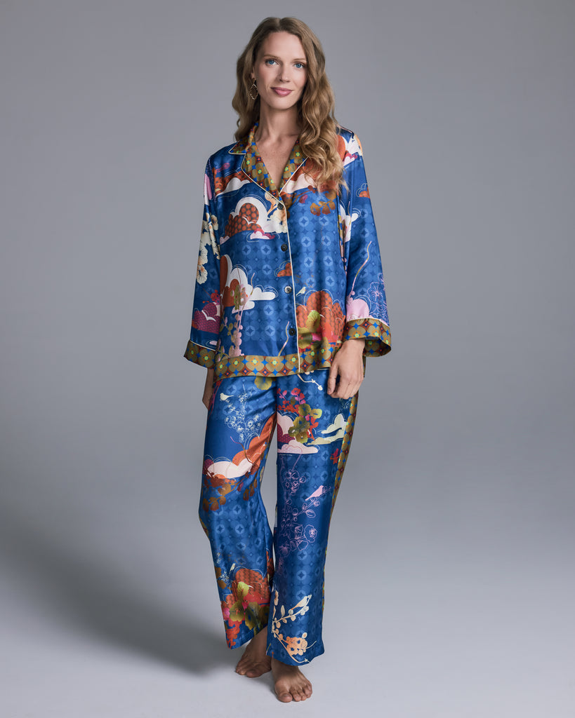 The Isa Tori Blue pajama from Karma on the Rocks is is crafted from a vibrant sapphire silk with patterning in shades of orange, pink, red, and olive green