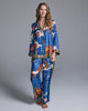 The Isa Tori Blue pajama from Karma on the Rocks is is crafted from a vibrant sapphire silk with patterning in shades of orange, pink, red, and olive green