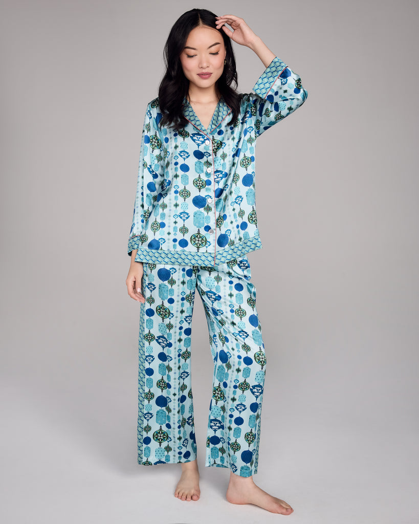 Karma on the Rocks Chochin Aqua silk pajama is crafted from a luxurious blue silk charmeuse with a Japanese-inspired print showcasing geometric lantern designs in shades of blue, white, teal, and green with a contrast print in a navy, teal and white cloud pattern