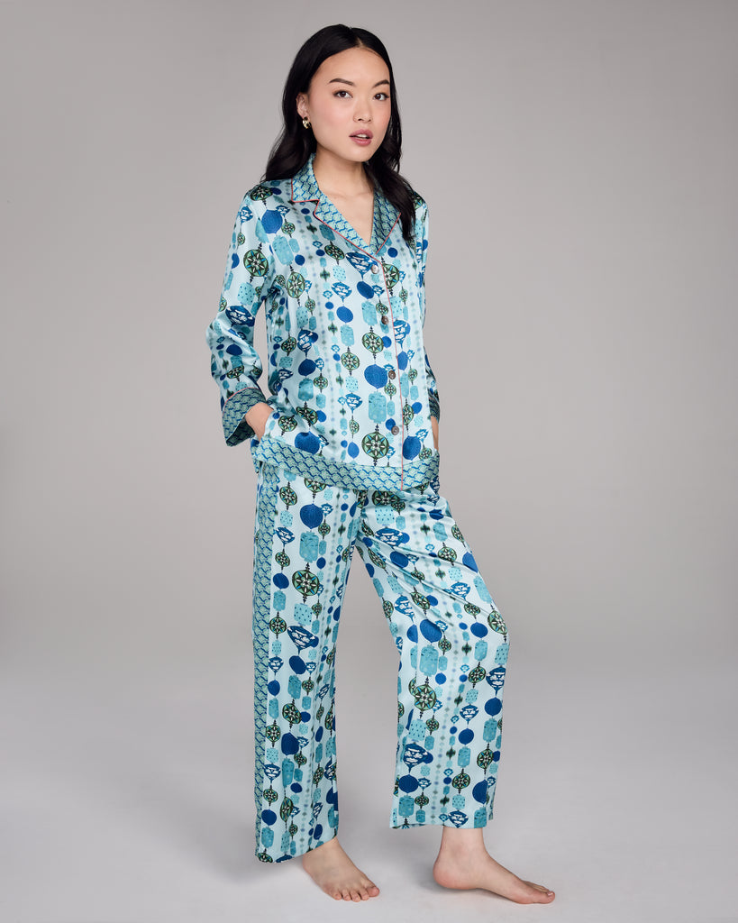 The classic button-down top on the Chochin Aqua Isa pajama from Karma on the Rocks has a generous fit with a notched collar, coral piping, and contrast print at the collar, cuffs and hem