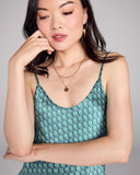 The Kumo Green Edo Silk slip dress from Karma on the Rocks is crafted from a navy blue silk charmeuse with a teal, green and white cloud pattern