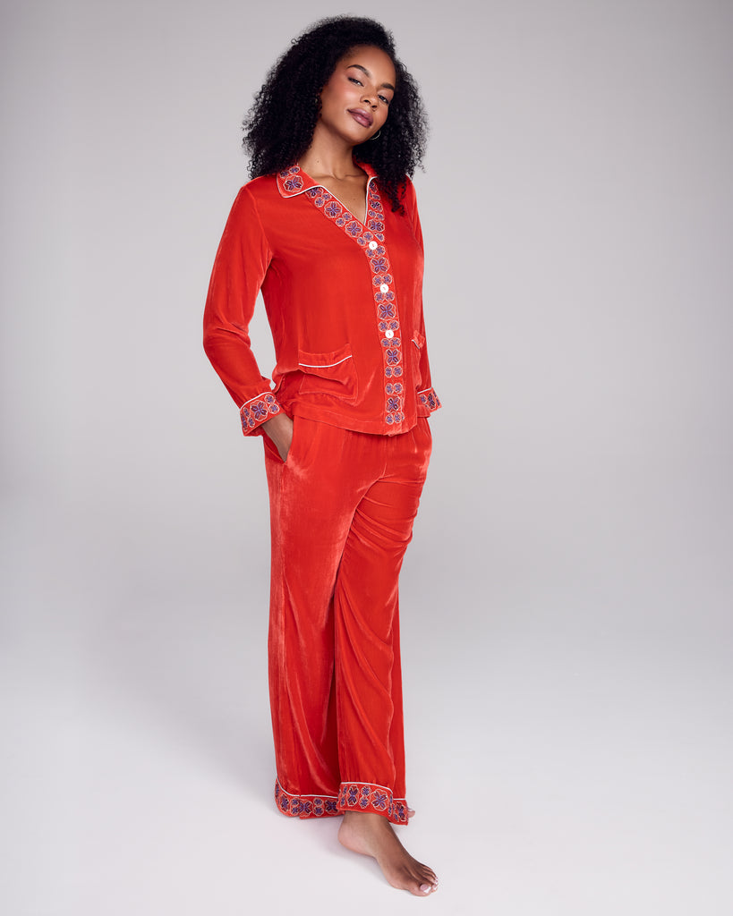 The Tokyo red velvet pajama from Karma on the Rocks has a  tailored red velvet button down top with the geometric embroidery at the v neckline and narrow collar, white piping, and mother of pearl buttons