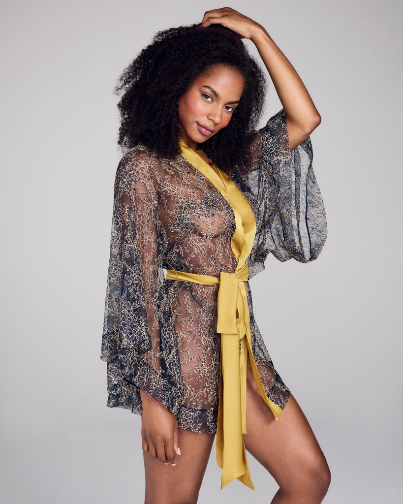Elegant Merle Noir robe is crafted entirely from transparent navy and gold floral lace with ochre silk binding at the neck and an ochre silk belt&nbsp;