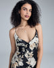 Ankle-length wrap dress from Merle Noir is crafted from a black silk with a Valentino white and gold floral print at the top