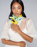 Cheerful silk scarf from Ika Paris showcases a profusion of sunflowers against a sky-blue background
