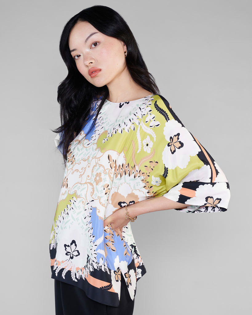 Draped St Tropez silk top from Christine Vancouver showcases a floral pattern in shades of black, white, tan, chartreuse green, sky blue and coral