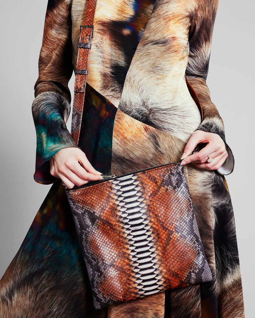 Cross-body purse from Elisabeth Weinstock is crafted from snakeskin in shades of brown, orange, grey and tan