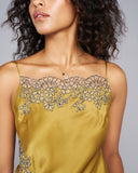 Gold silk camisole from Merle Noir showcases the finest couture construction techniques and is appliquéd with champagne floral lace outlined with navy blue embroidery 