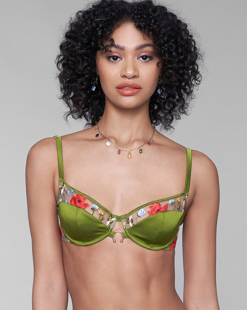 Underwired Cerelia bra has silk lined cups with embroidered accents, 24k plated u-hook detailing at the center front, and embroidered accents at the side band