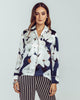 Camo Bloom silk blouse is patterned with an oversized magnolia print in shades of black, navy, white, and brown